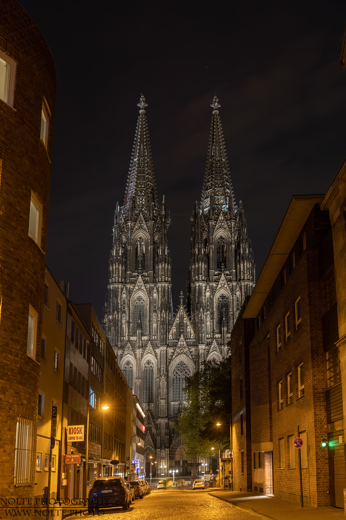 Die beiden Türme und das Hauptportal des Kölner Doms von einer angrenzenden Strasse aus.