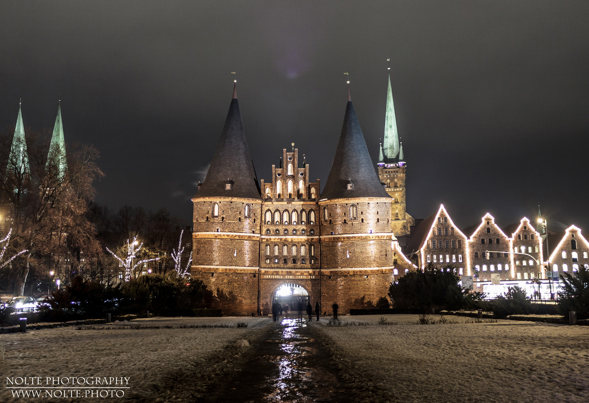 Holstentor, Salzspeicher und Park bei Nacht mit Winterschmuck