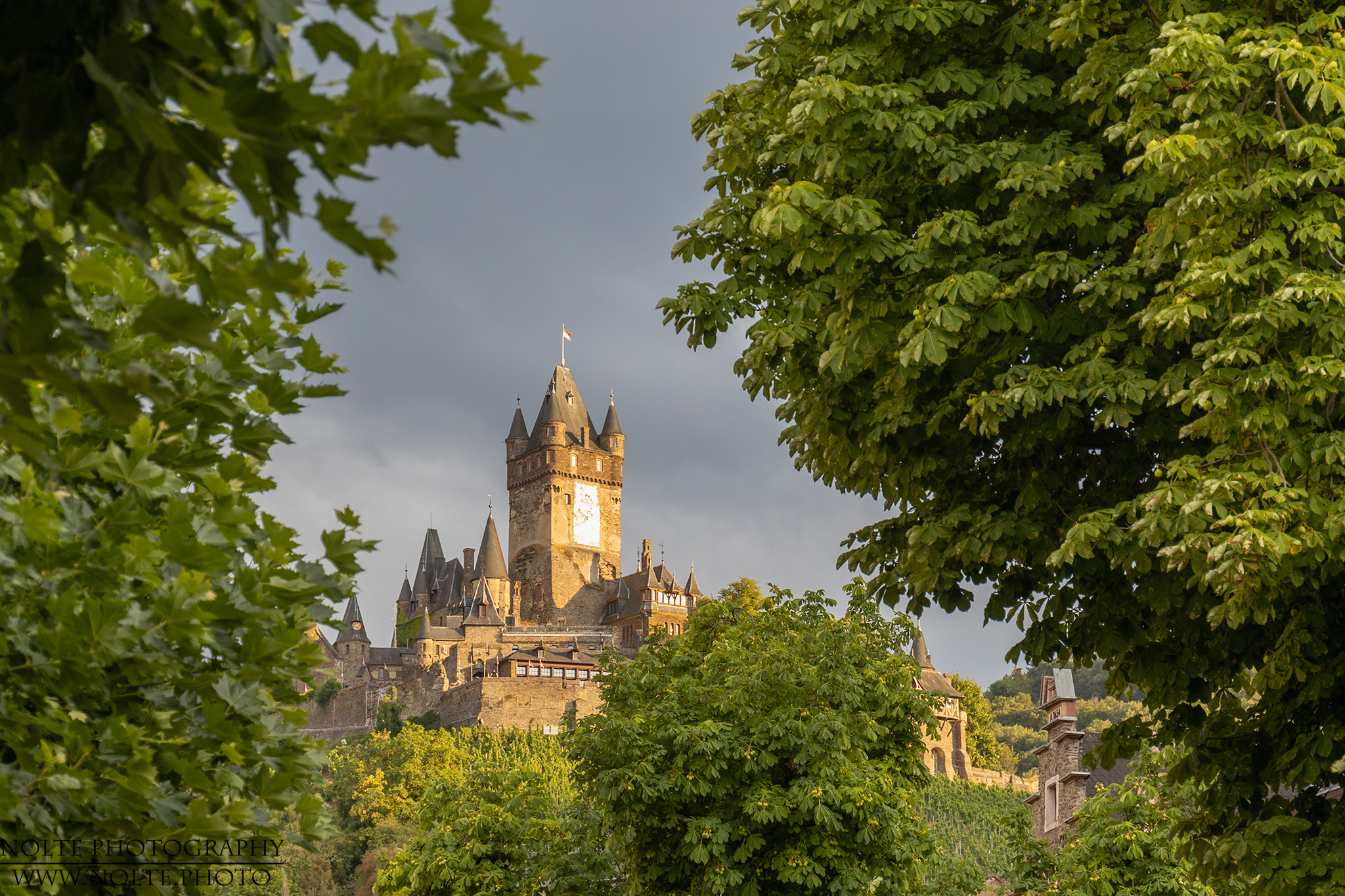 Reichsburg Cochem vom Dorf aus bei Sonnenuntergang gesehen.