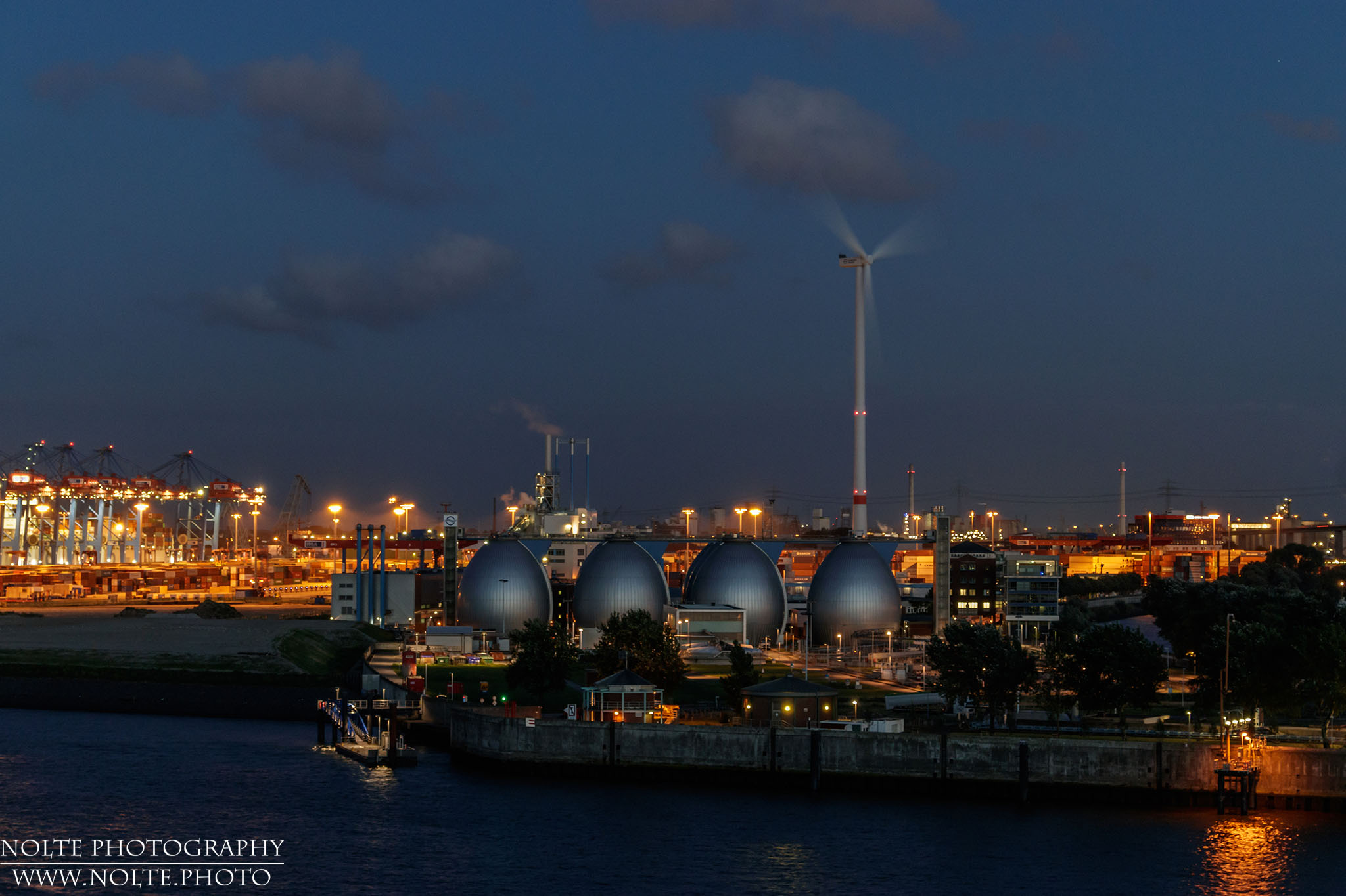 Blick auf das Hafengelände mit der Eierförmigen Tanks und dem Windkraftwerk