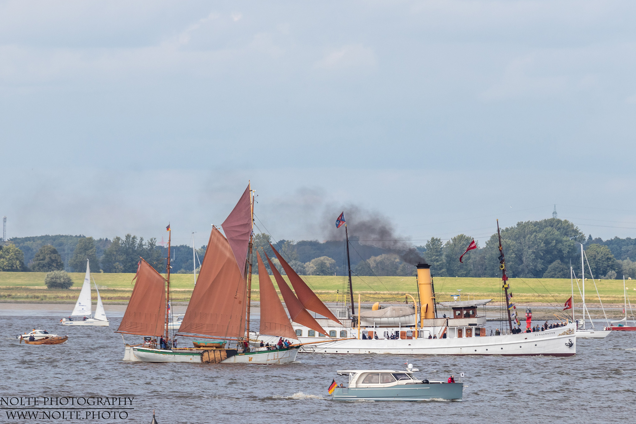 Dampfschiff Schaarhörn und ein Ewer mit kleineren Booten auf der Elbe